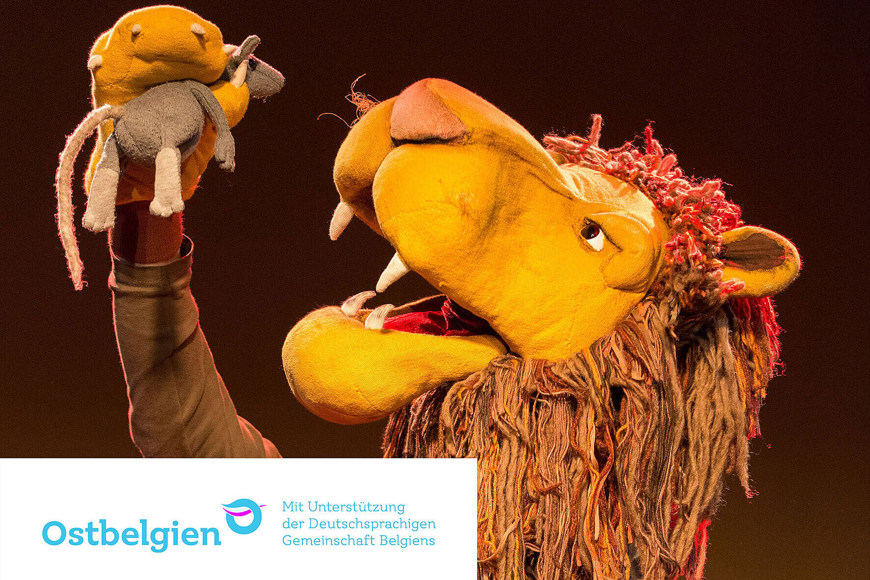 Ein Stofflöwe mit einer Stoffmaus in der Pfote.