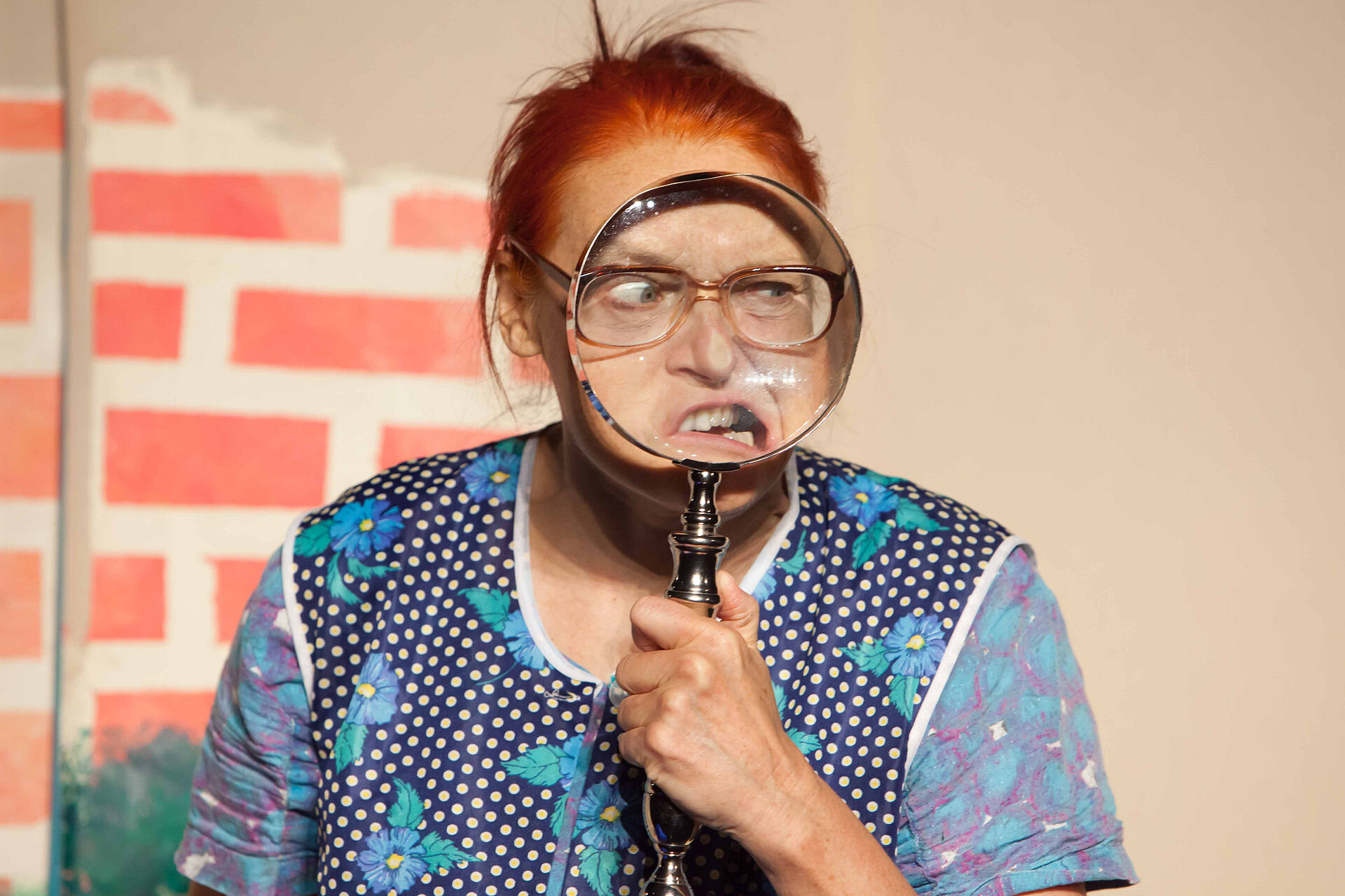 Eine Frau guckt durch eine große Lupe.