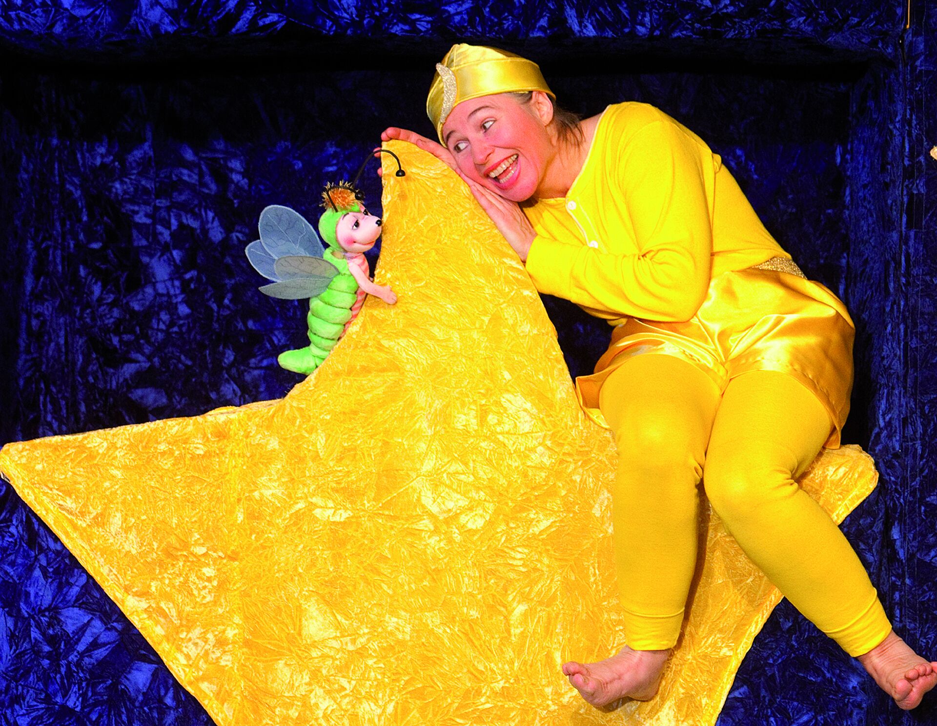 Ein gelb gekleideter Mann sitzt auf einem gelben Stern.